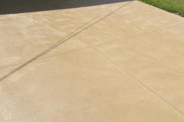 Vibrant red coloured concrete driveway leading to a modern home