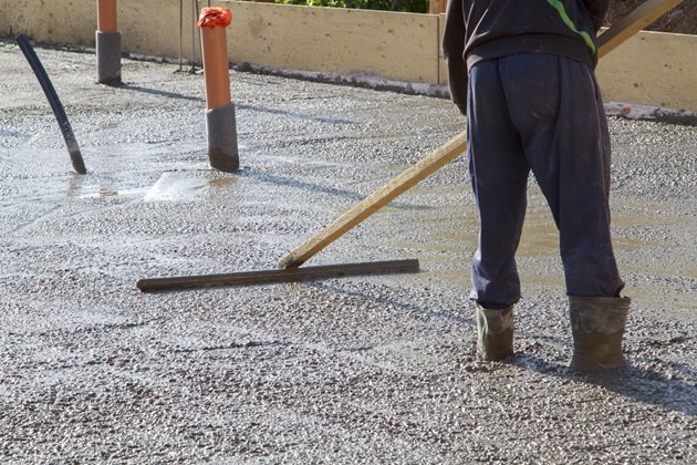 Close-up of spalling concrete patio surface during restoration process